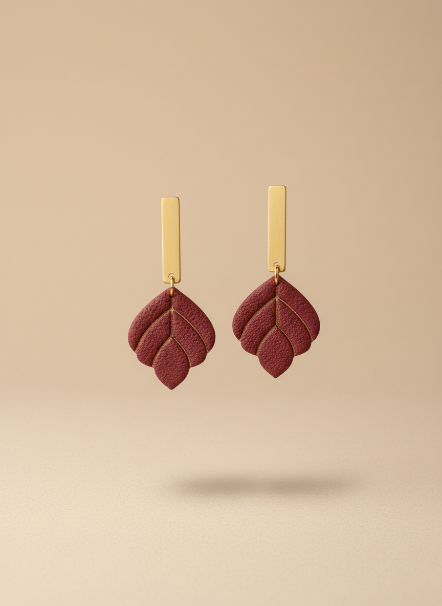 Burgundy earrings on beige background