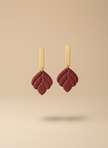 Burgundy earrings on beige background