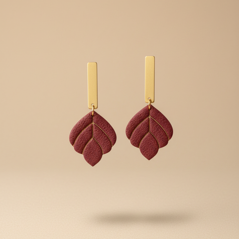 Burgundy earrings on beige background