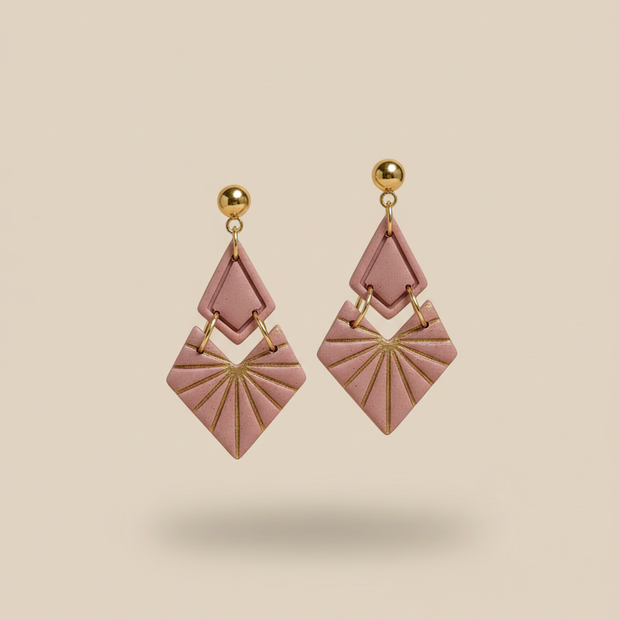 Dusty pink geometric earrings on beige background