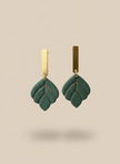 Green earrings on beige background