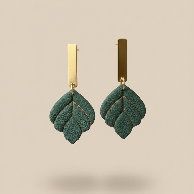 Green earrings on beige background