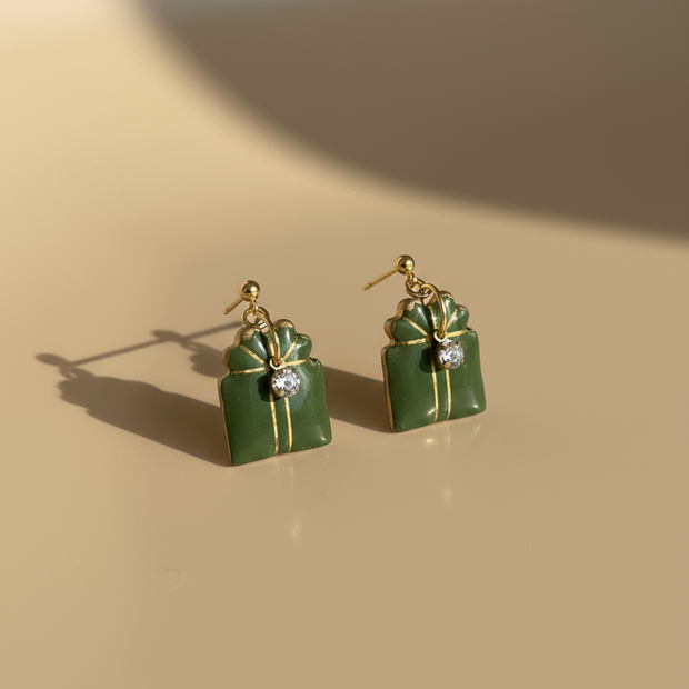 Green gift box earrings on professional background